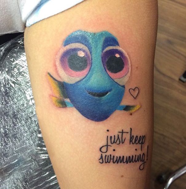 a tattoo with an image of a blue fish on it's arm that says just keep swimming