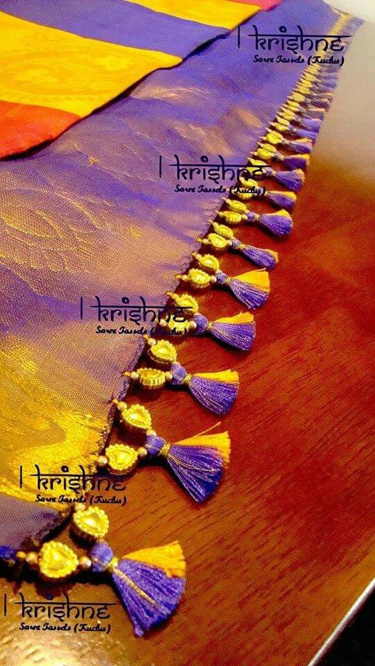 the tassels on this sari are made with gold and purple thread, which is