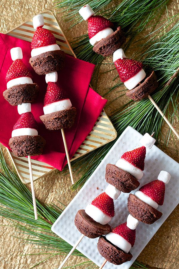 chocolate covered strawberries and marshmallows on skewers with pine needles