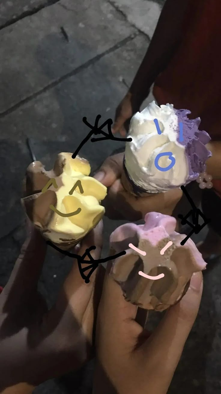 three people holding cupcakes in their hands with numbers painted on the top and bottom