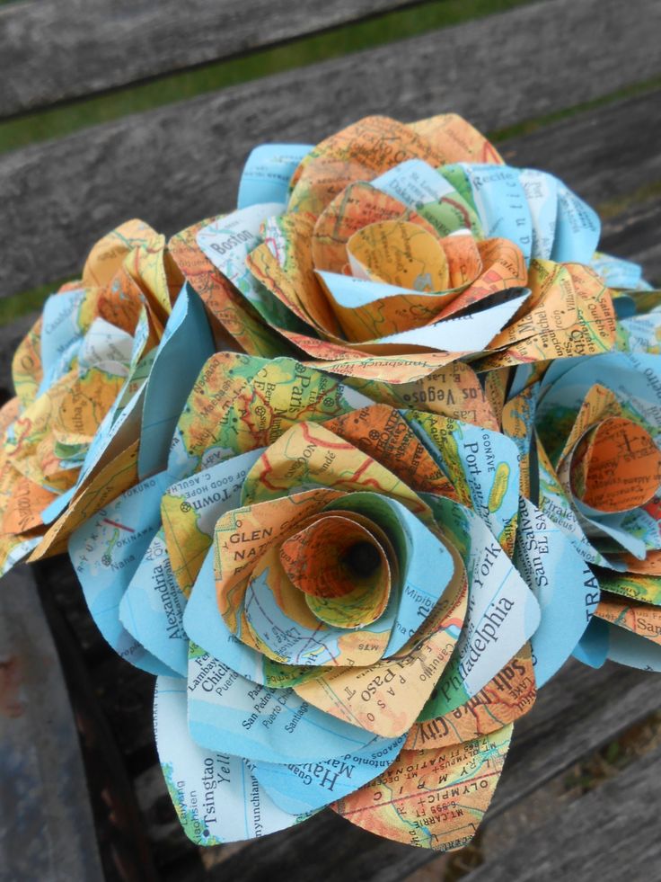 a bunch of paper flowers sitting on top of a wooden bench