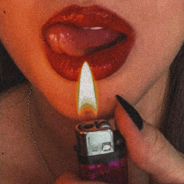 a woman holding a lighter in her mouth with the light on it's side