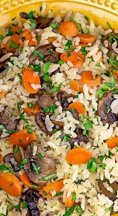 a yellow bowl filled with rice, carrots and mushrooms