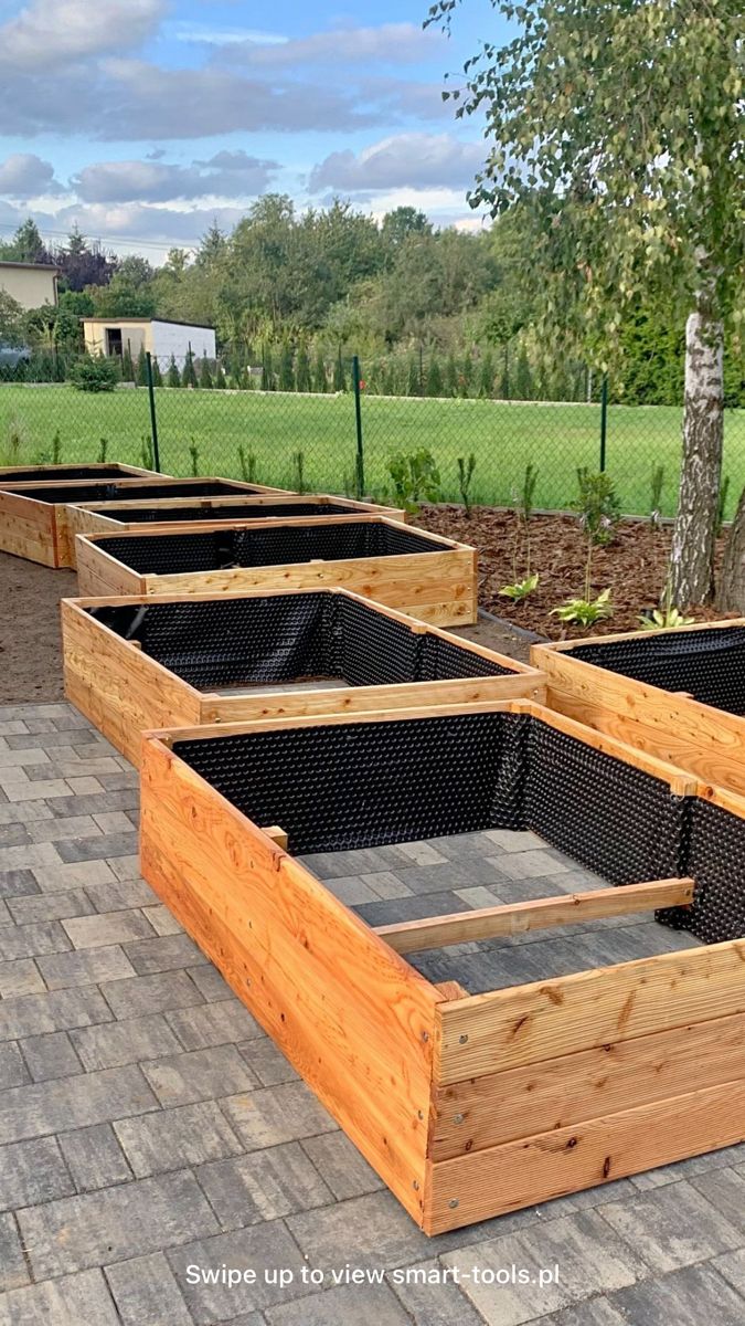 four wooden raised planters sitting on top of a brick patio