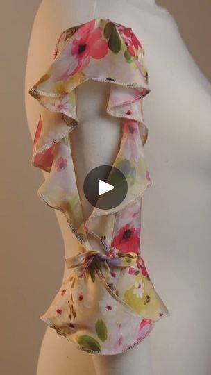 a white mannequin wearing a pink and yellow flowered scarf on it's head