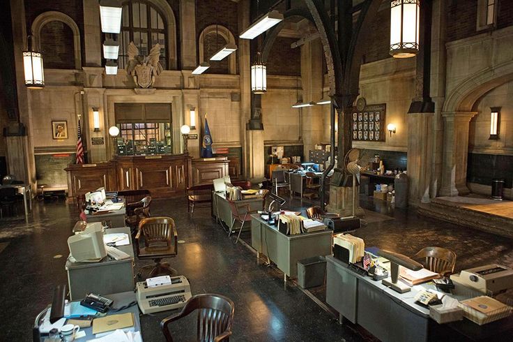 an old building with lots of desks and chairs in front of windows on either side of the room