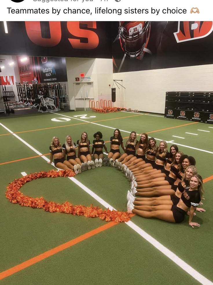 a group of cheerleaders sitting in the middle of a circle on a football field