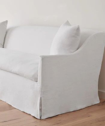 a white couch sitting on top of a hard wood floor