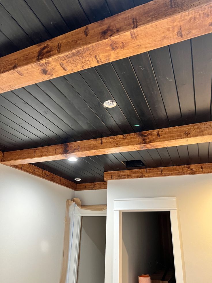 an unfinished room with white walls and wood beams