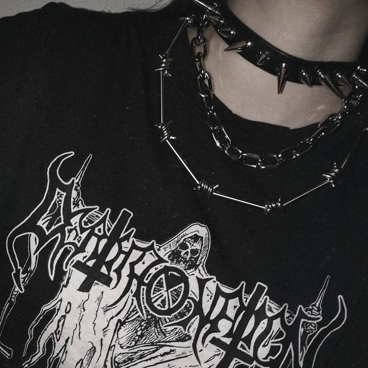 a person wearing a black shirt with chains around their neck