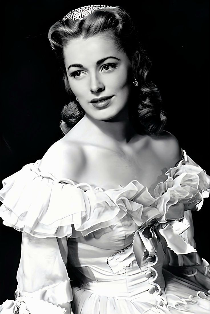 a black and white photo of a woman in a dress with a tiara on her head