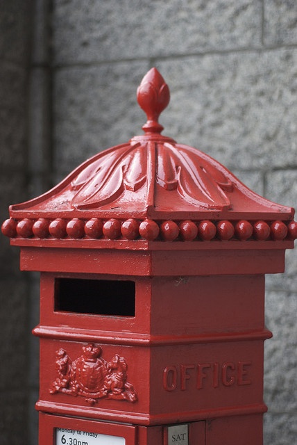 a red mailbox sitting in front of a brick wall