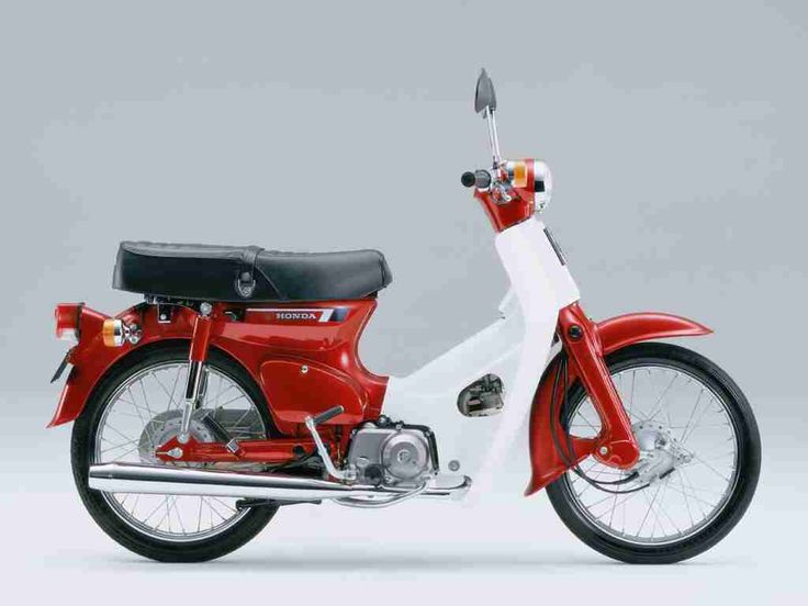 a red and white motorcycle parked on top of a gray background