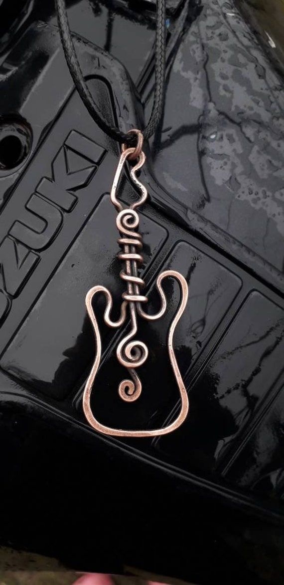 a black and gold necklace with a guitar on it