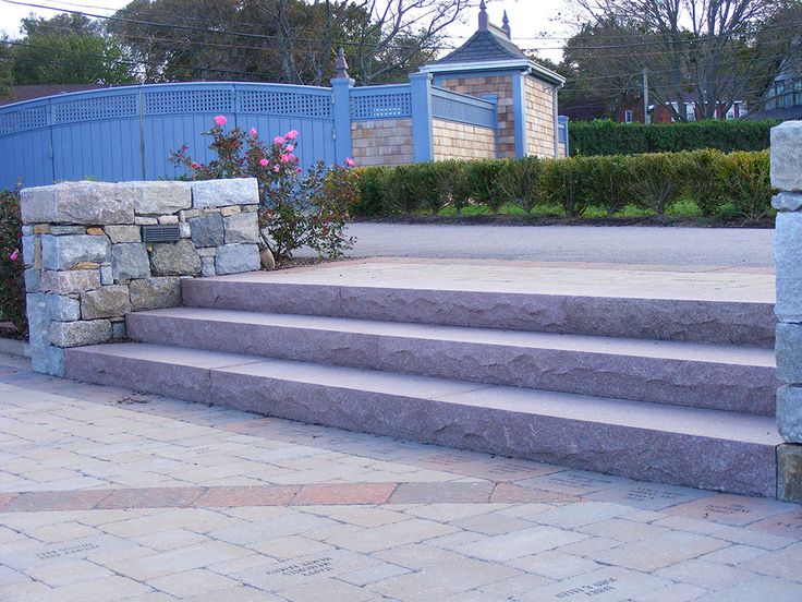 the steps are made of stone and have flowers growing on each step, along with a blue gate