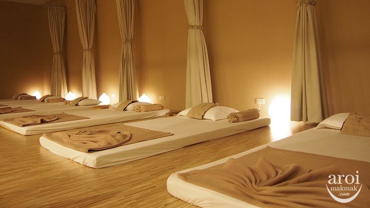 there are many beds in the room with towels on them and lights on each side