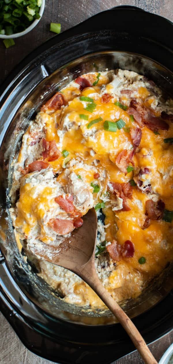 a crock pot filled with eggs, bacon and cheese