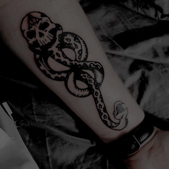 a black and white photo of a tattoo on someone's arm with an octopus