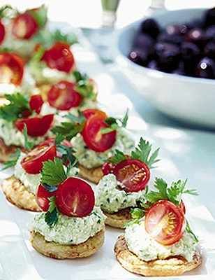 small appetizers are lined up on a table with tomatoes and other food items