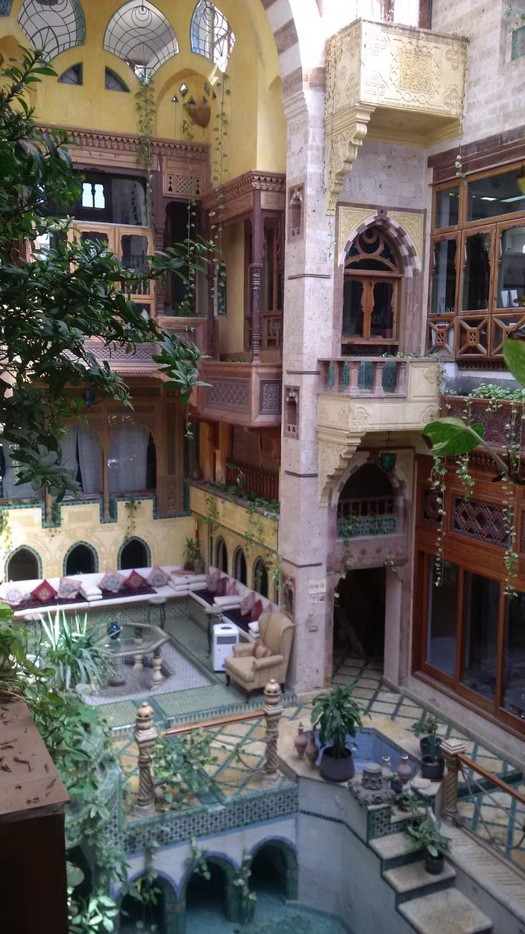 the inside of an old building with lots of windows and plants on the balcony area