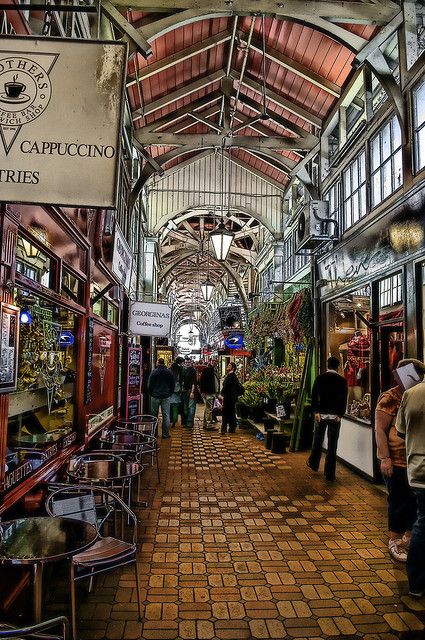 the inside of a building with people walking through it and shops on either side of the walkway