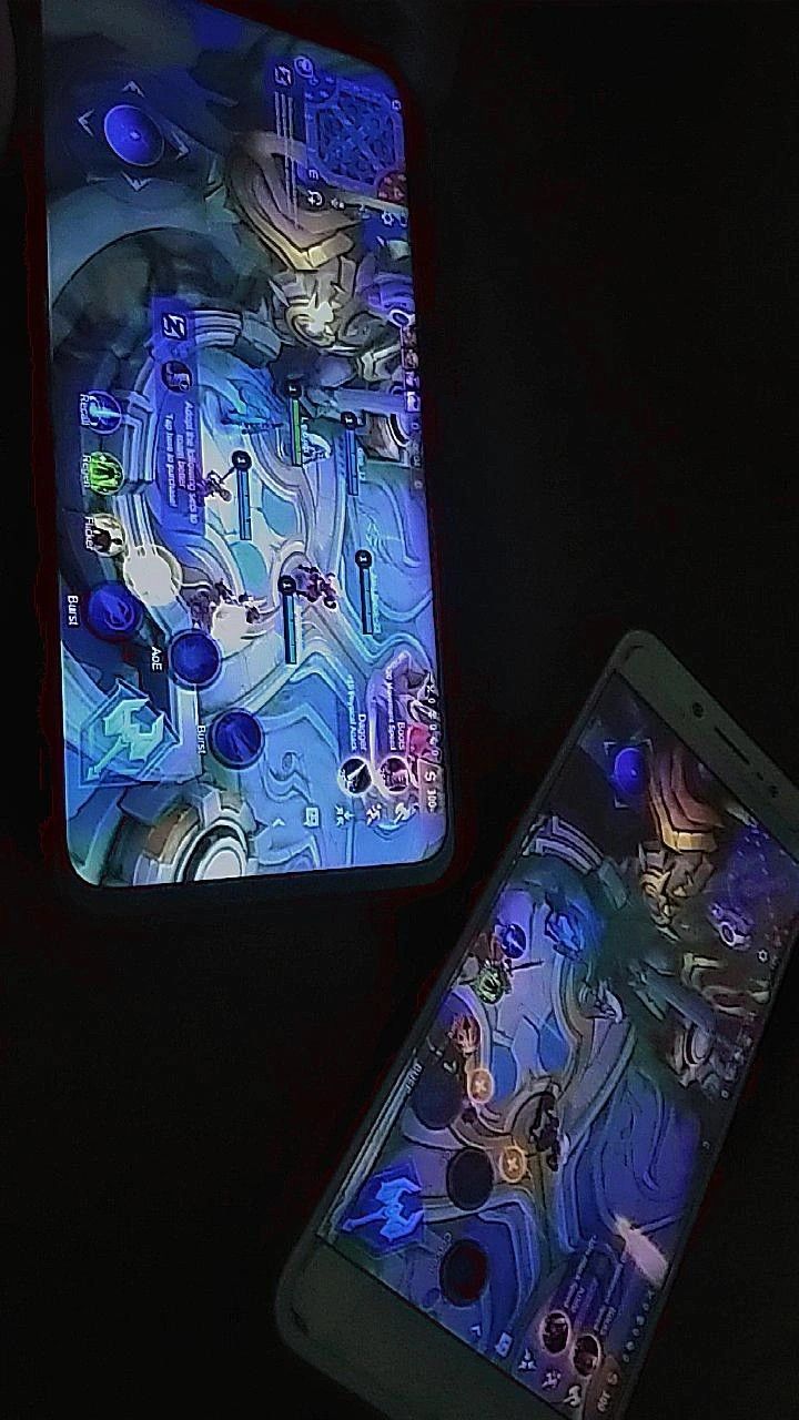 two cell phones sitting next to each other on a black surface with blue and red designs