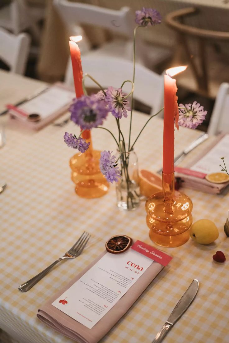 the table is set with flowers, candles and menus for an elegant dinner party