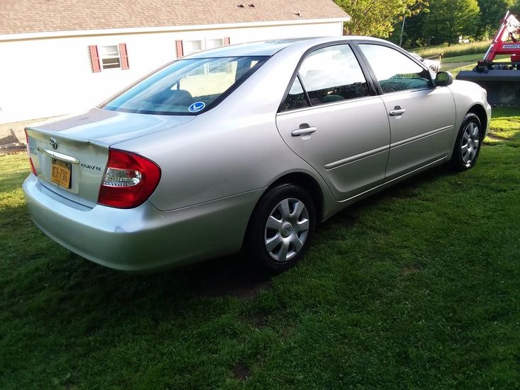 a silver car is parked in the grass