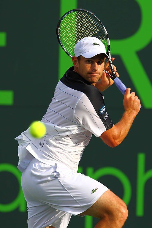 a man holding a tennis racquet on top of a tennis court with a ball in the air