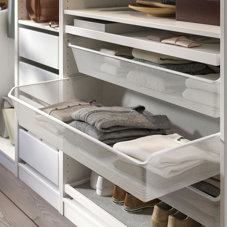 an organized closet with shoes, sweaters and other items on the shelve