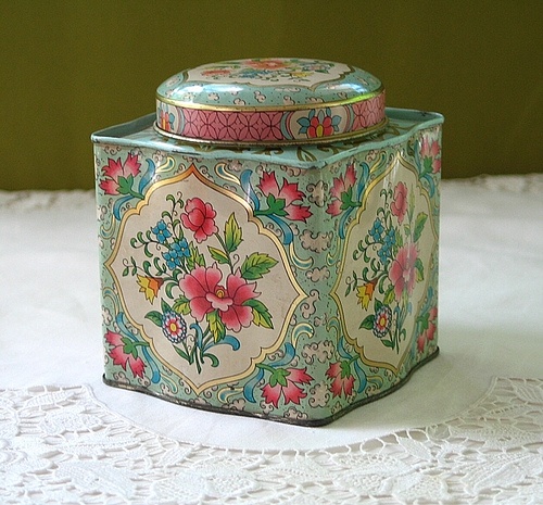 an ornately decorated box sitting on top of a white doily covered tablecloth