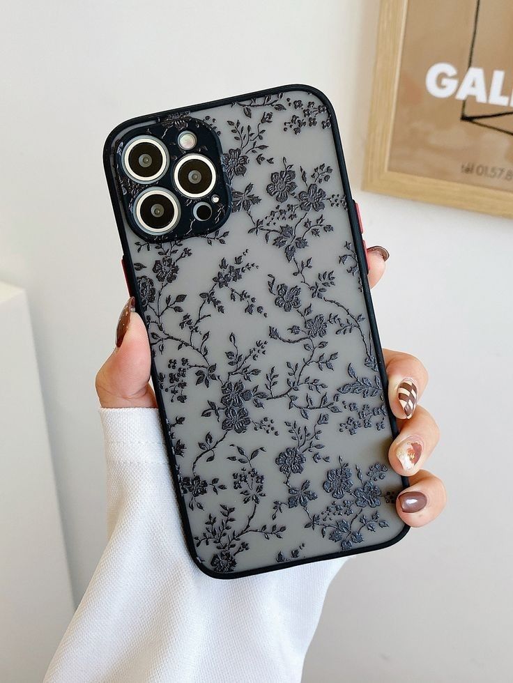 a woman holding an iphone case with flowers on it