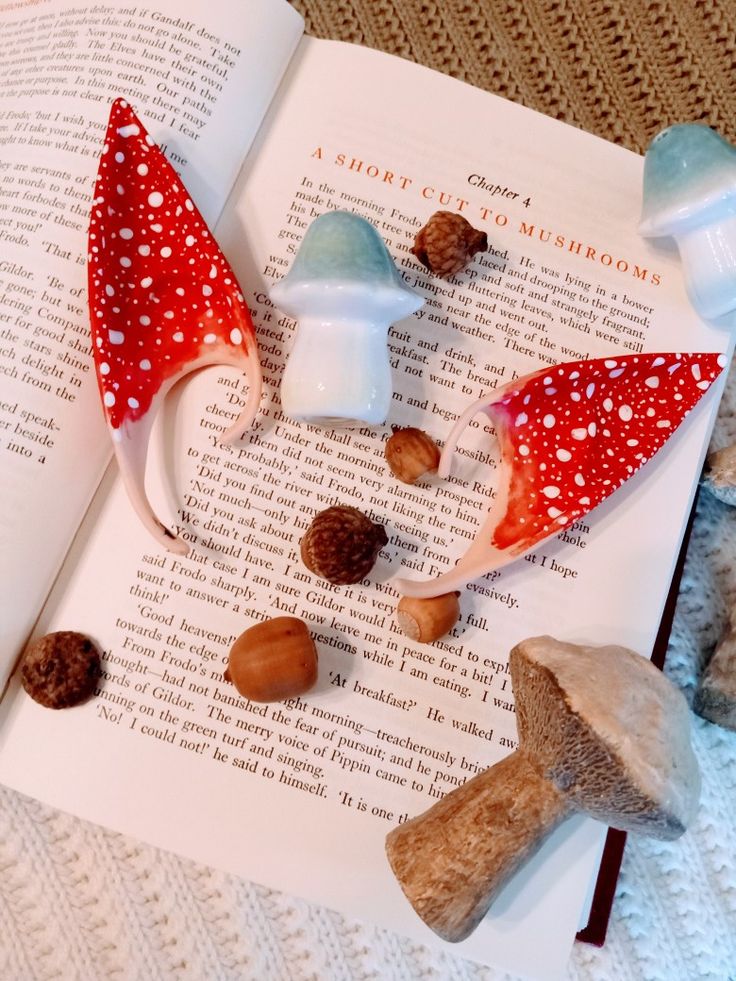 an open book sitting on top of a table next to stuffed animals and mushrooms,