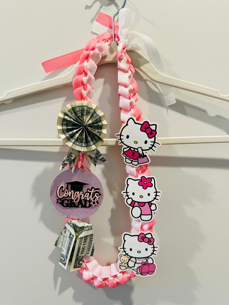 the hello kitty hair tie is hanging on a hanger with other items attached to it