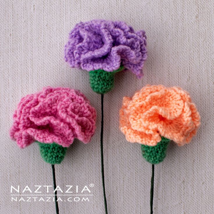 three crocheted flowers sitting next to each other