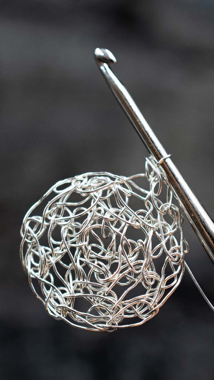 a knitting needle is hooked up to a ball of yarn that has been stitched together