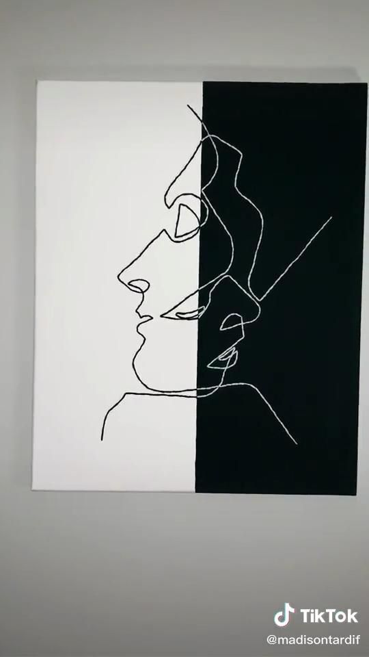 a black and white painting on a wall with a woman's face in the middle