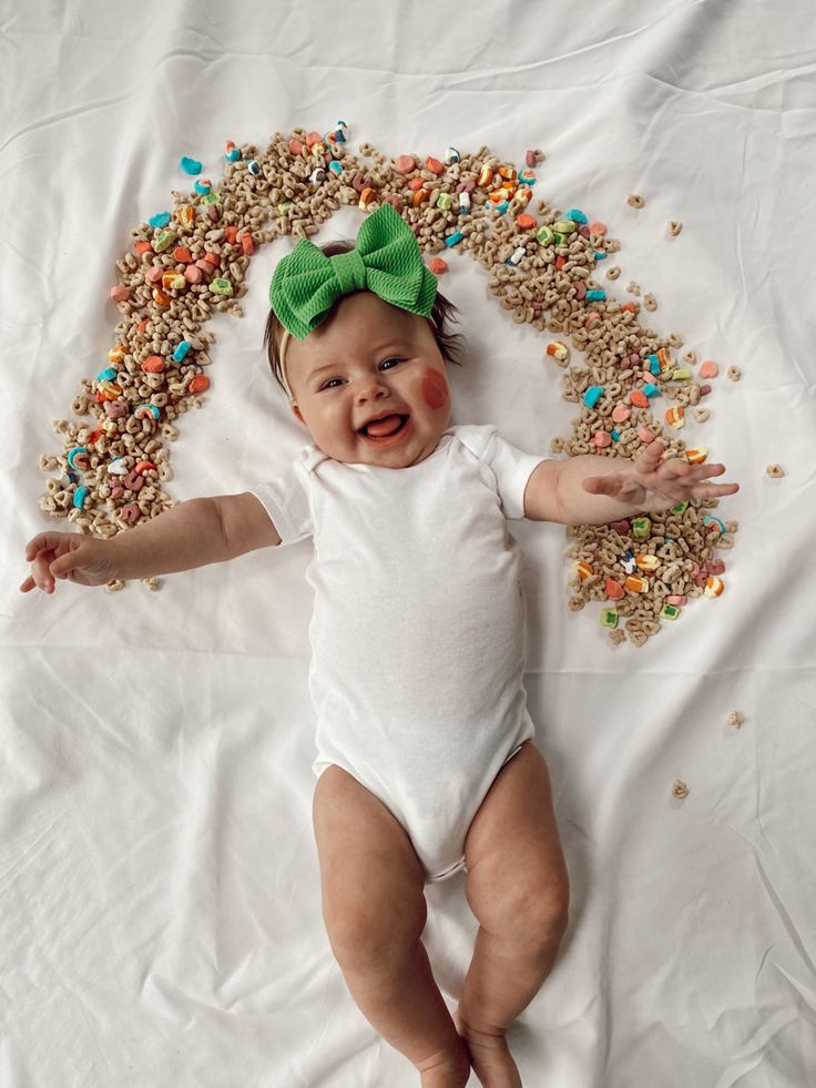 a baby with sprinkles all over it's body laying on a white sheet