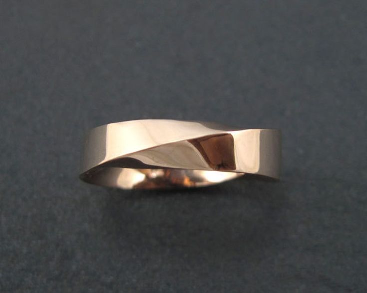 a close up of a gold ring on a black surface with no one around it