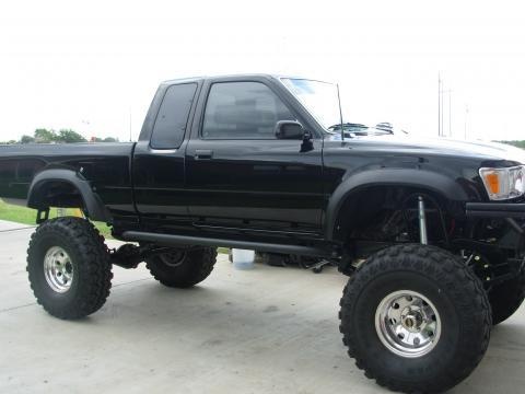 a large black truck parked on top of a driveway