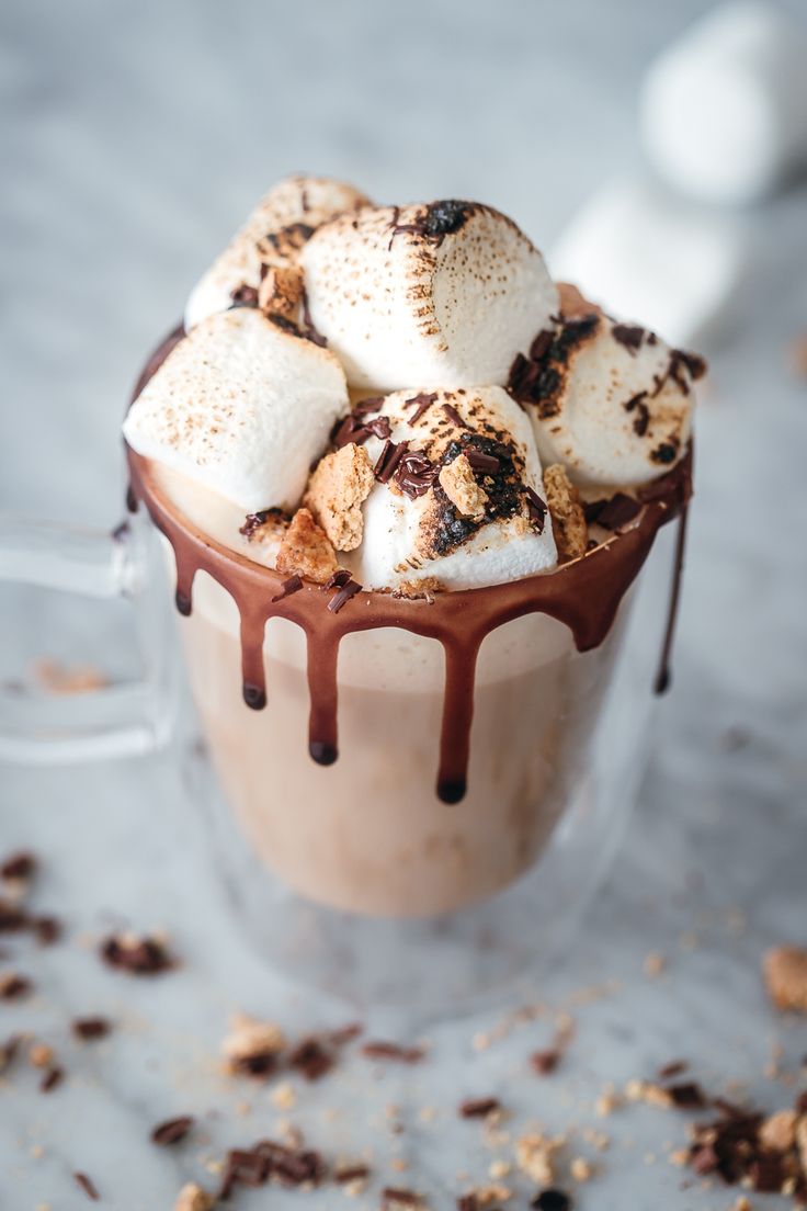 hot chocolate and marshmallows in a glass mug with drizzle on top