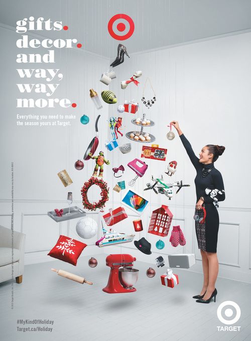 a woman standing in front of a christmas tree with gifts hanging from the top and below it