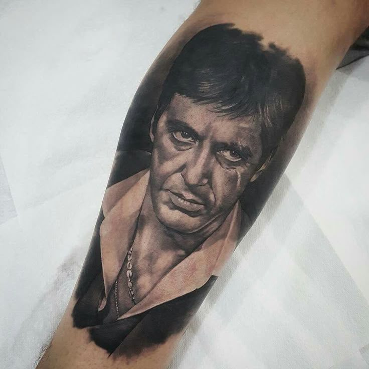 a man's arm with a black and grey portrait on it