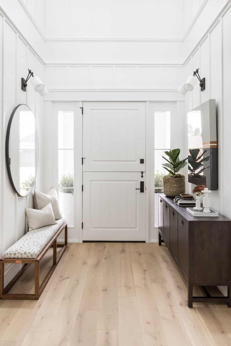 an entryway with white walls and wood flooring is pictured in this home's interior