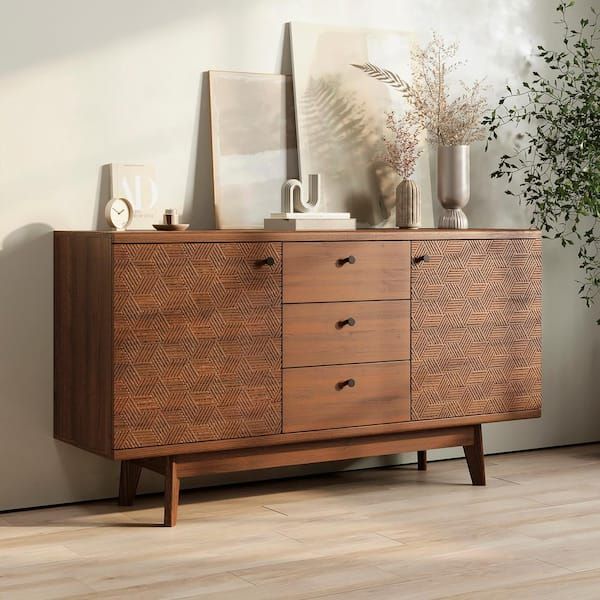 a wooden dresser sitting next to a plant on top of a hard wood floor