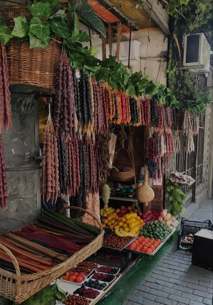 an outdoor fruit and vegetable stand with lots of fresh produce hanging from it's sides