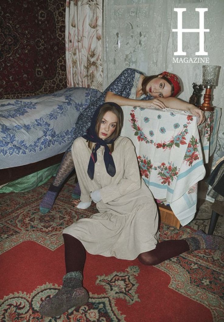 two women laying on the floor in front of a bed