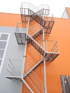 an orange building with metal railings and fire escape stairs