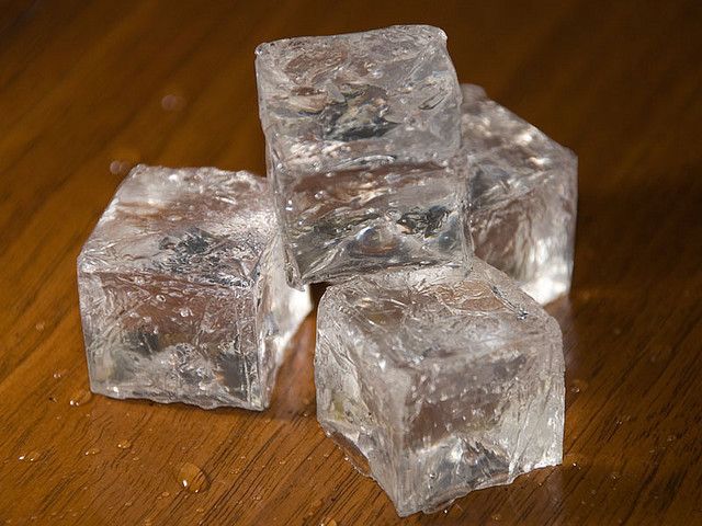 four ice cubes sitting on top of a wooden table