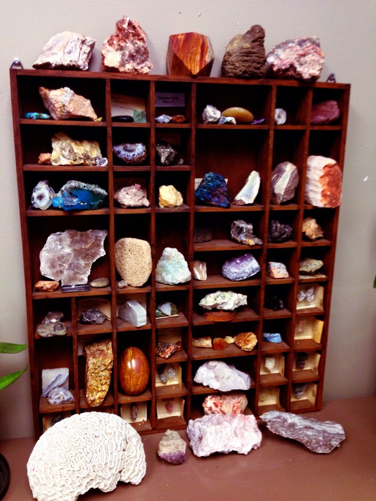 a wooden shelf filled with lots of different types of rocks and stones on top of it